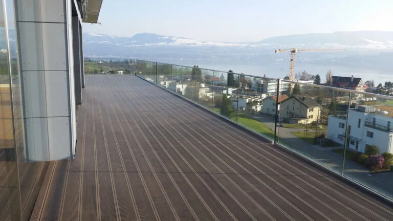 WPC roof terrace with dark boards and glass balustrade overlooking Lake Zurich